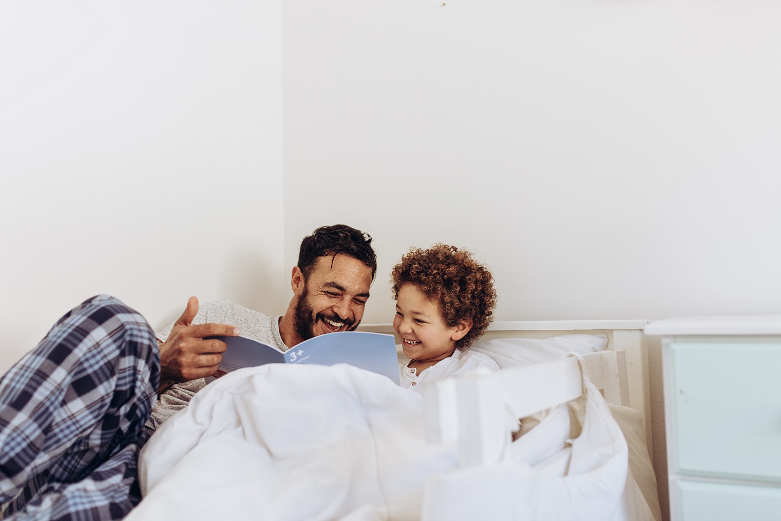 dad and son reading in bed