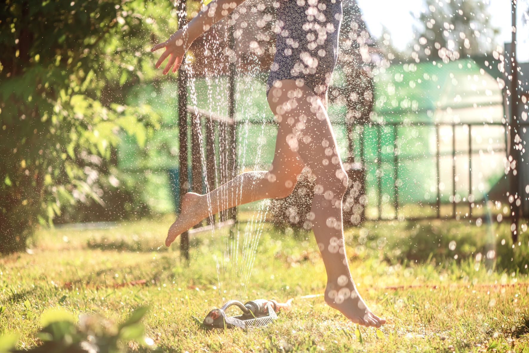 kids running through sprinkler summer heat fun safety prevention hot