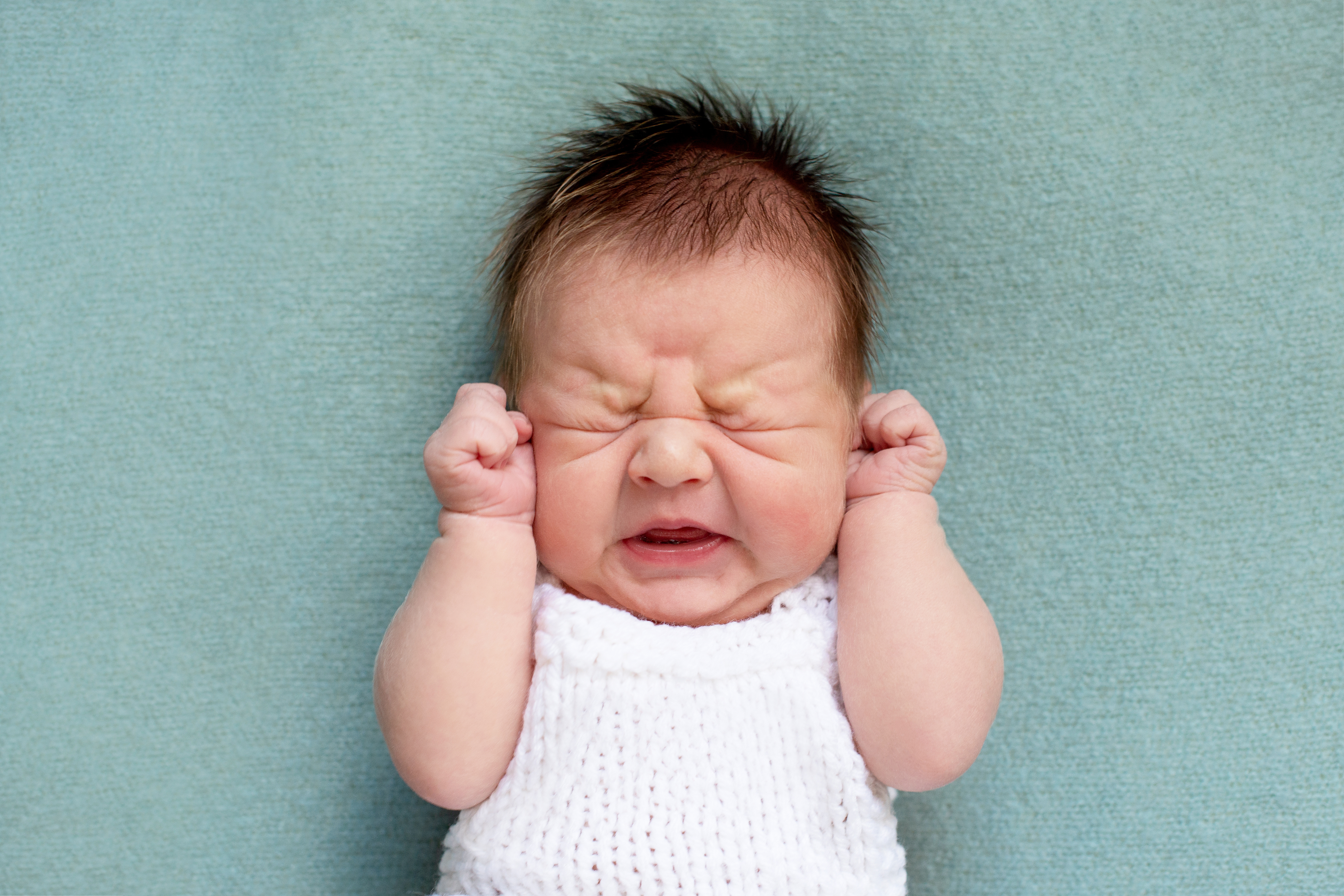 infant constipation baby crying uncomfortable face clenching fists