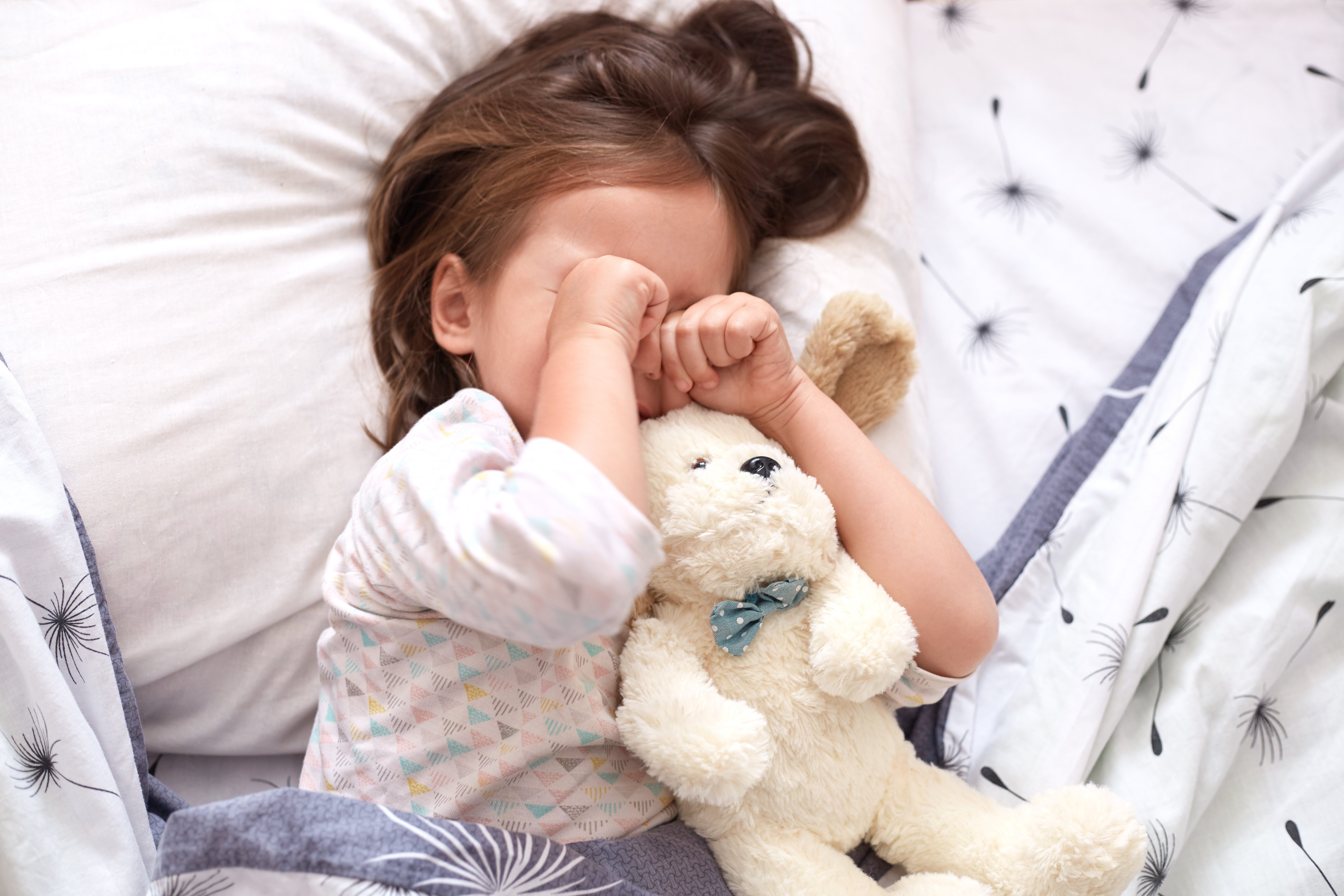 little girl with hands over face hand foot mouth disease rash illness fever